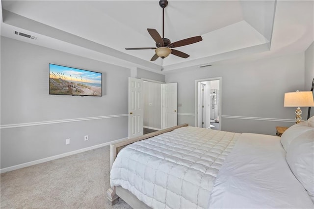 2500 Ashbourne Dr, Lawrenceville, GA 30043 - carpeted bedroom featuring a tray ceiling, ensuite bathroom, and a ceiling fan