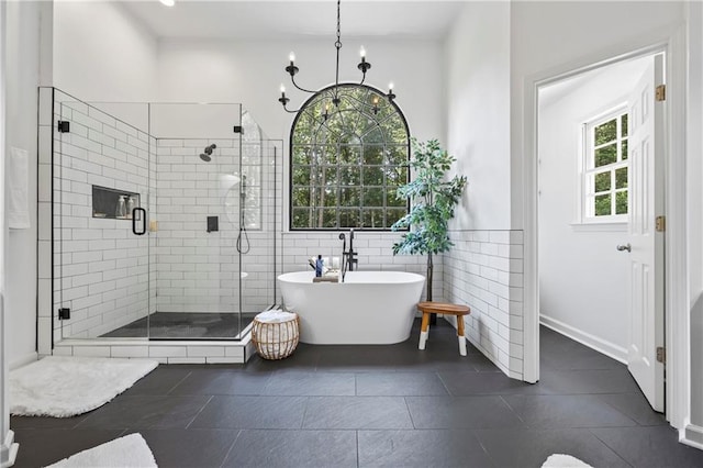 2500 Ashbourne Dr, Lawrenceville, GA 30043 - full bathroom with a soaking tub, a shower stall, a chandelier, tile patterned floors, and tile walls