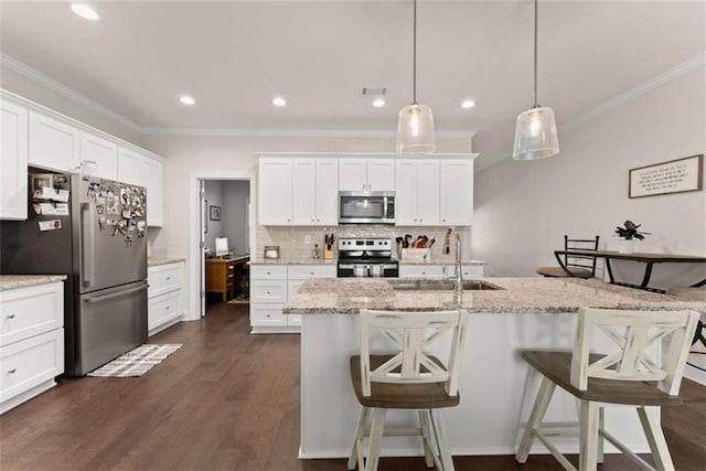 kitchen featuring a sink, ornamental molding, a breakfast bar, and appliances with stainless steel finishes
