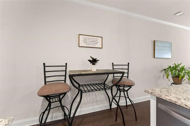 dining room featuring visible vents, baseboards, ornamental molding, and dark wood-style floors