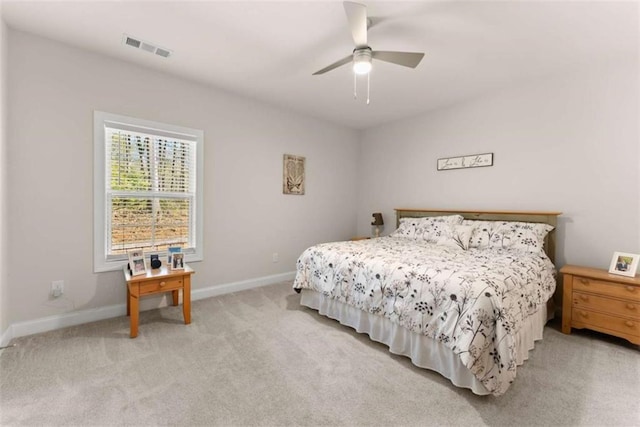 bedroom with light colored carpet, visible vents, baseboards, and ceiling fan