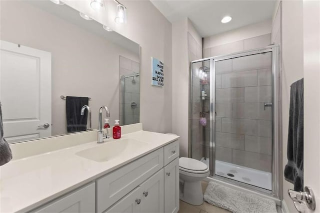 bathroom featuring a stall shower, tile patterned flooring, vanity, and toilet