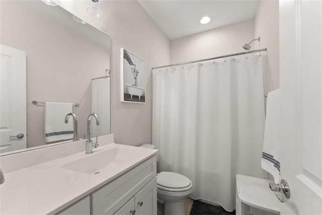 full bathroom featuring toilet, vanity, and a shower with curtain