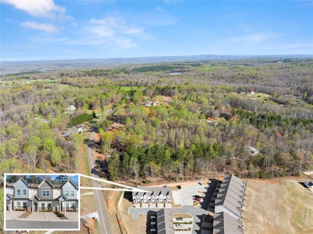birds eye view of property with a view of trees