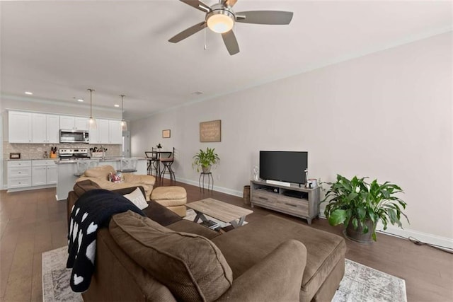 living area featuring dark wood-type flooring, baseboards, ceiling fan, and recessed lighting