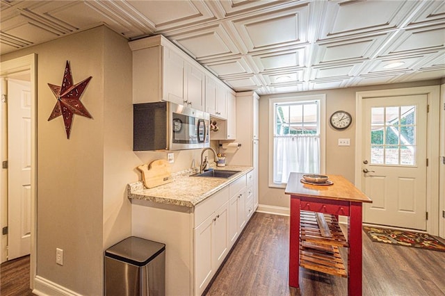 6369 Timber Creek Trl, Dahlonega, GA 30533 - kitchen with stainless steel microwave, dark wood-style floors, an ornate ceiling, white cabinetry, and light stone counters