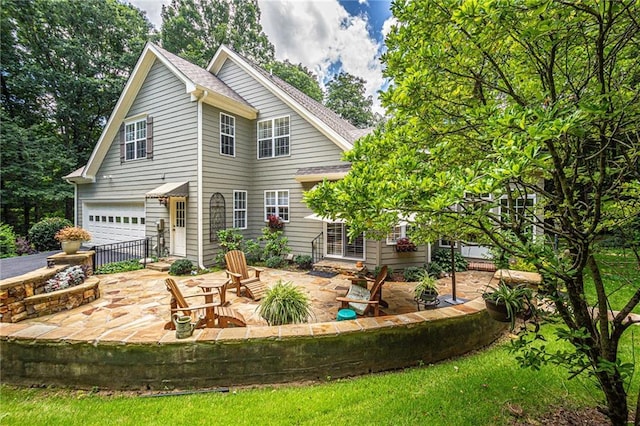 6369 Timber Creek Trl, Dahlonega, GA 30533 - rear view of house featuring an attached garage, a shingled roof, a patio, and driveway