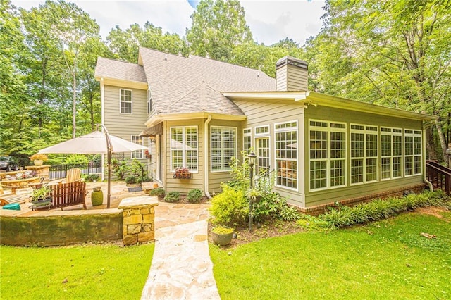 6369 Timber Creek Trl, Dahlonega, GA 30533 - back of house with a patio, a chimney, a shingled roof, and a sunroom