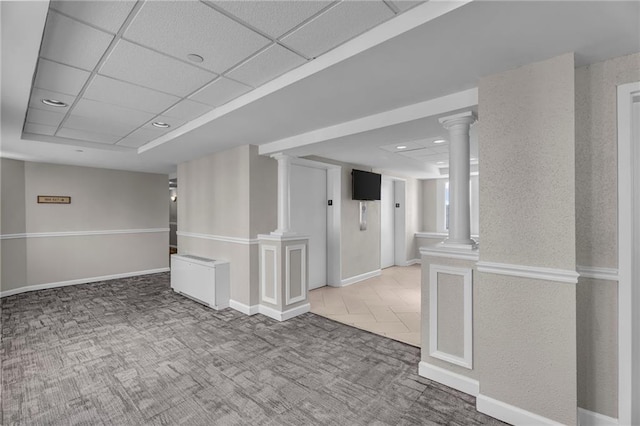 interior space featuring baseboards, carpet, a drop ceiling, recessed lighting, and ornate columns
