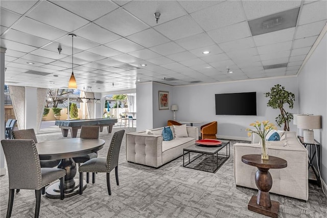 living room featuring a paneled ceiling and baseboards