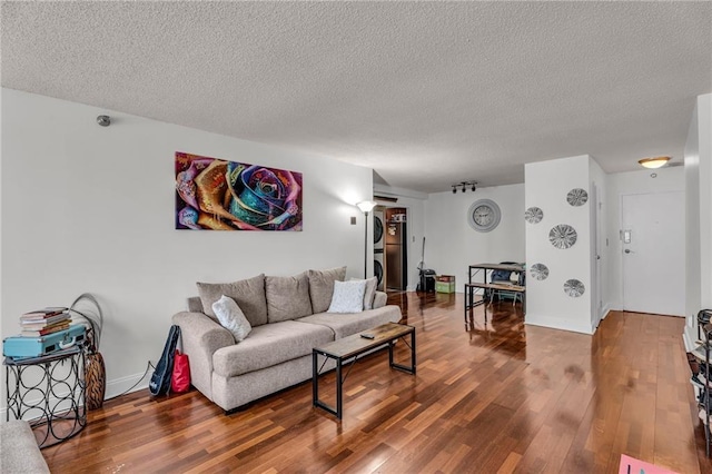 living area featuring wood finished floors, baseboards, and a textured ceiling