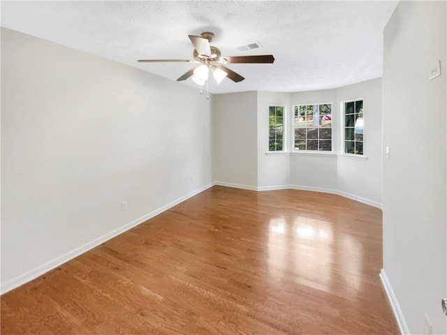 unfurnished room featuring a textured ceiling, light hardwood / wood-style floors, and ceiling fan