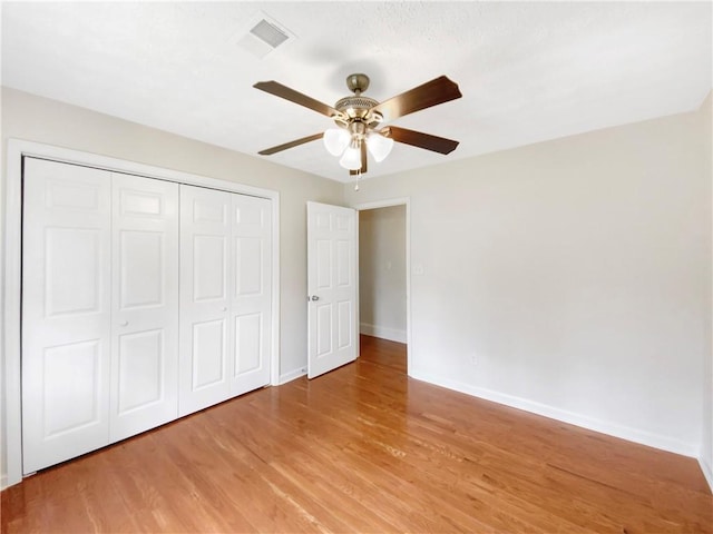 unfurnished bedroom with a closet, light hardwood / wood-style flooring, and ceiling fan