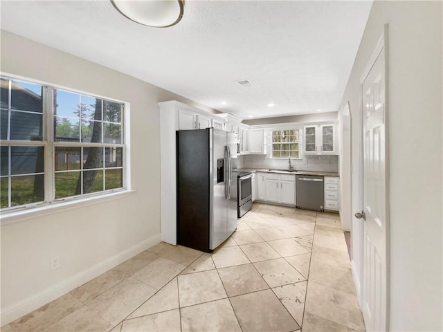 kitchen featuring backsplash, white cabinets, sink, a wealth of natural light, and appliances with stainless steel finishes