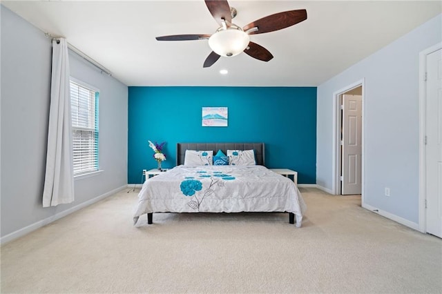 bedroom featuring a ceiling fan, an accent wall, baseboards, and carpet floors