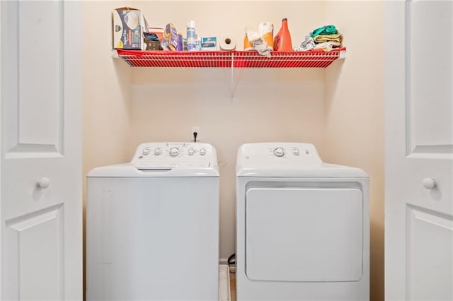 clothes washing area with washing machine and clothes dryer and laundry area