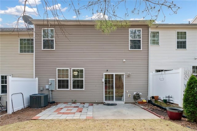 rear view of property with central air condition unit, a patio, and fence