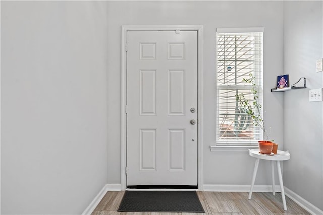 entryway with baseboards and wood finished floors