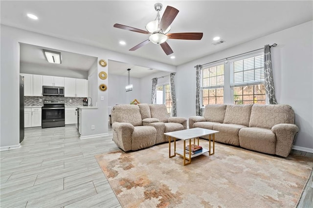 living room with wood finish floors, visible vents, a ceiling fan, recessed lighting, and baseboards