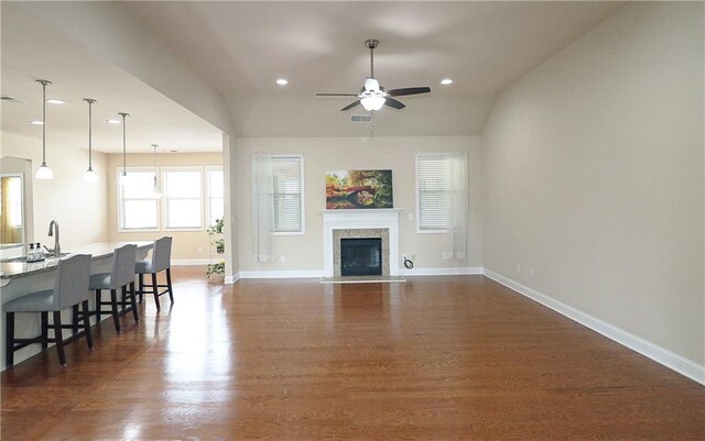 living area featuring ceiling fan, baseboards, recessed lighting, dark wood finished floors, and a high end fireplace