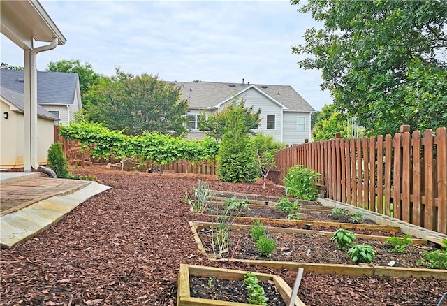 fenced yard featuring a garden