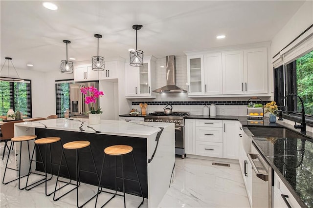 2432 Thompson Mill Rd, Gainesville, GA 30506 - kitchen with wall chimney exhaust hood, stainless steel appliances, light marble finish floors, recessed lighting, and a kitchen breakfast bar