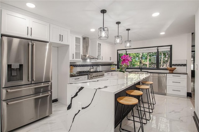 2432 Thompson Mill Rd, Gainesville, GA 30506 - kitchen featuring appliances with stainless steel finishes, wall chimney range hood, recessed lighting, light marble finish flooring, and tasteful backsplash