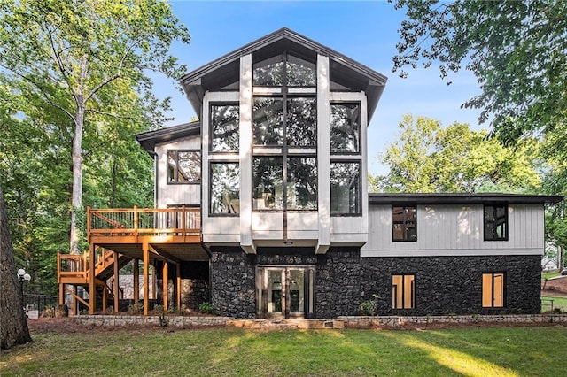2432 Thompson Mill Rd, Gainesville, GA 30506 - back of house featuring stone siding, a yard, a wooden deck, stairs, and a sunroom