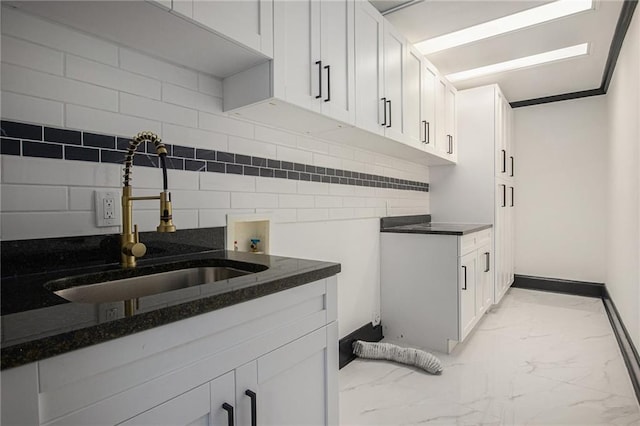 2432 Thompson Mill Rd, Gainesville, GA 30506 - kitchen with a sink, light marble finish floors, dark stone countertops, white cabinetry, and baseboards