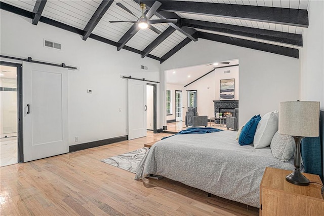 2432 Thompson Mill Rd, Gainesville, GA 30506 - bedroom with a barn door, light wood finished floors, access to outside, high vaulted ceiling, and wooden ceiling with exposed beams