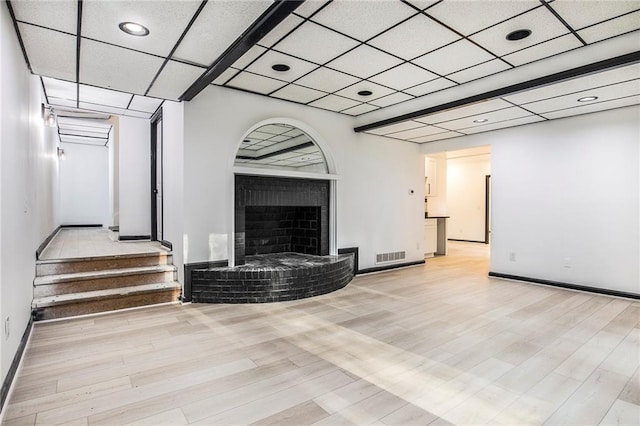 2432 Thompson Mill Rd, Gainesville, GA 30506 - unfurnished living room featuring wood finished floors, a paneled ceiling, baseboards, a brick fireplace, and recessed lighting