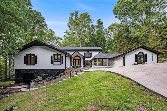 2432 Thompson Mill Rd, Gainesville, GA 30506 - tudor-style house with a front lawn, curved driveway, stucco siding, and stone siding
