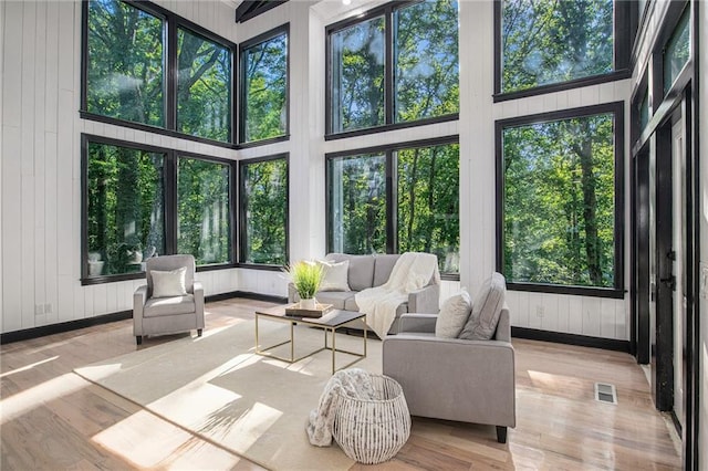 2432 Thompson Mill Rd, Gainesville, GA 30506 - sunroom featuring wood finished floors, wood walls, plenty of natural light, and baseboards
