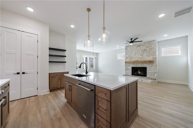 kitchen with stainless steel dishwasher, light wood-style flooring, ceiling fan, a sink, and visible vents