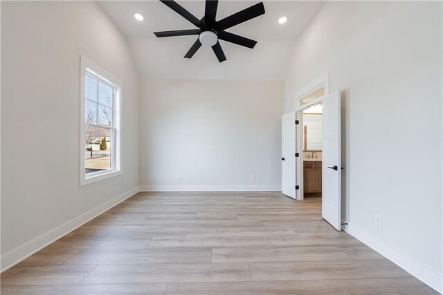empty room featuring lofted ceiling, light wood-style flooring, ceiling fan, baseboards, and recessed lighting