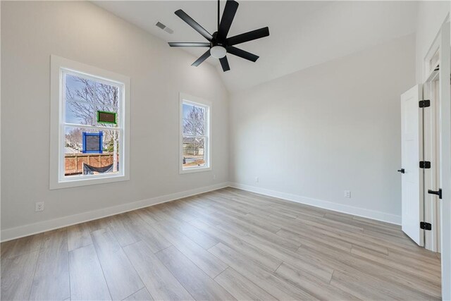 spare room featuring light wood-type flooring, visible vents, a ceiling fan, and baseboards
