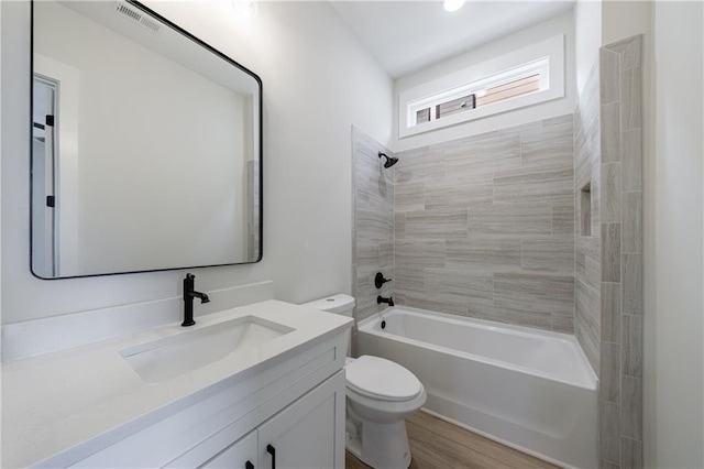 full bath featuring wood finished floors, visible vents, toilet, shower / washtub combination, and vanity