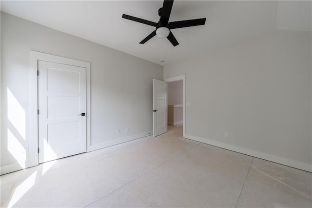 unfurnished bedroom with concrete floors, a ceiling fan, and baseboards