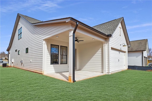 view of side of home featuring central air condition unit, a yard, a shingled roof, and a ceiling fan