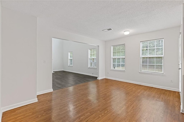 spare room featuring dark hardwood / wood-style flooring and a textured ceiling