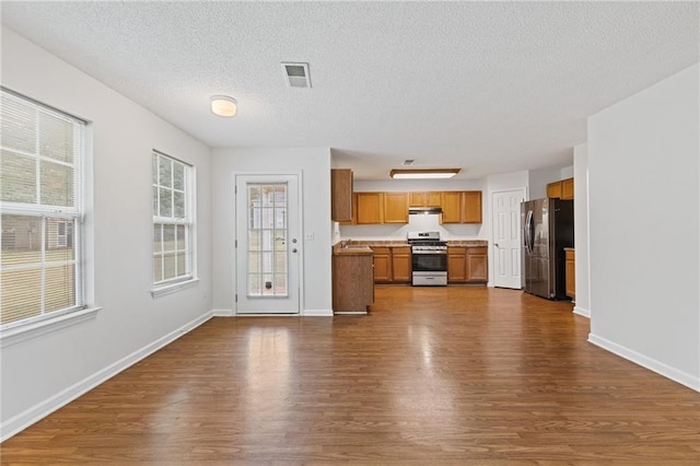 kitchen with dark wood-type flooring, stainless steel appliances, sink, and a textured ceiling