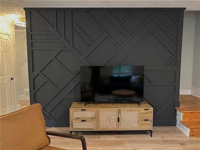 interior details featuring baseboards, wood finished floors, and a decorative wall