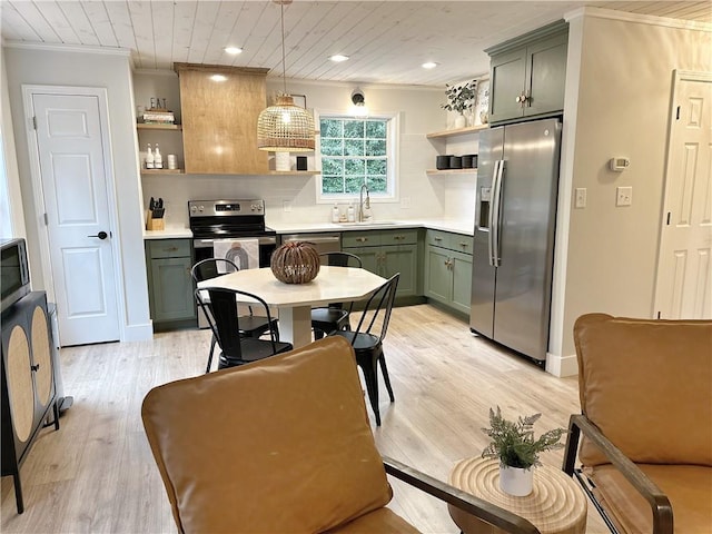 kitchen with ornamental molding, open shelves, a sink, appliances with stainless steel finishes, and green cabinets