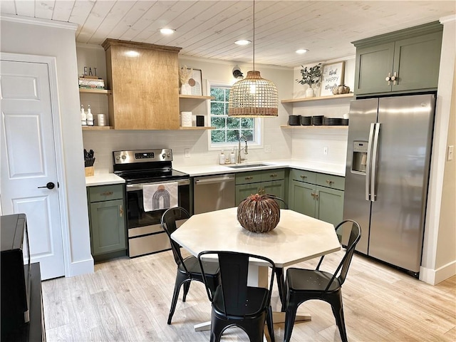 kitchen with a sink, open shelves, appliances with stainless steel finishes, and green cabinetry