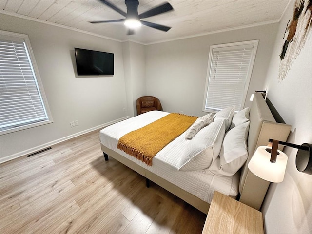 bedroom featuring visible vents, light wood-style flooring, crown molding, and baseboards