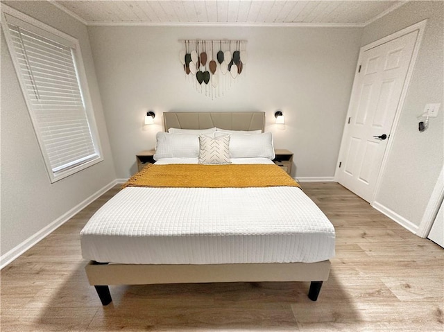 bedroom featuring baseboards, light wood finished floors, and ornamental molding