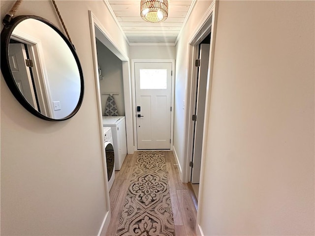 hallway with baseboards, washing machine and dryer, ornamental molding, light wood-style flooring, and wooden ceiling