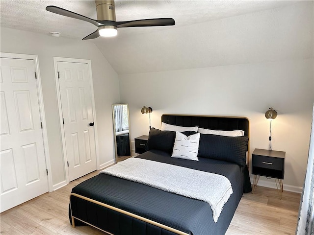 bedroom with baseboards, a ceiling fan, vaulted ceiling, and light wood finished floors