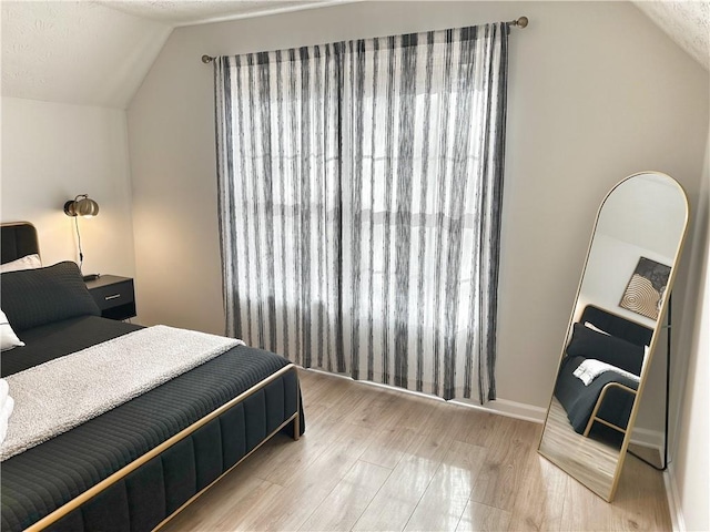 bedroom featuring lofted ceiling and wood finished floors