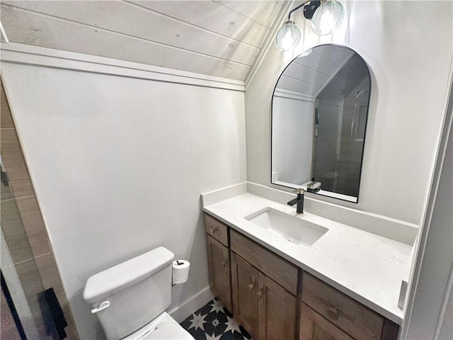 bathroom with vanity, lofted ceiling, and toilet